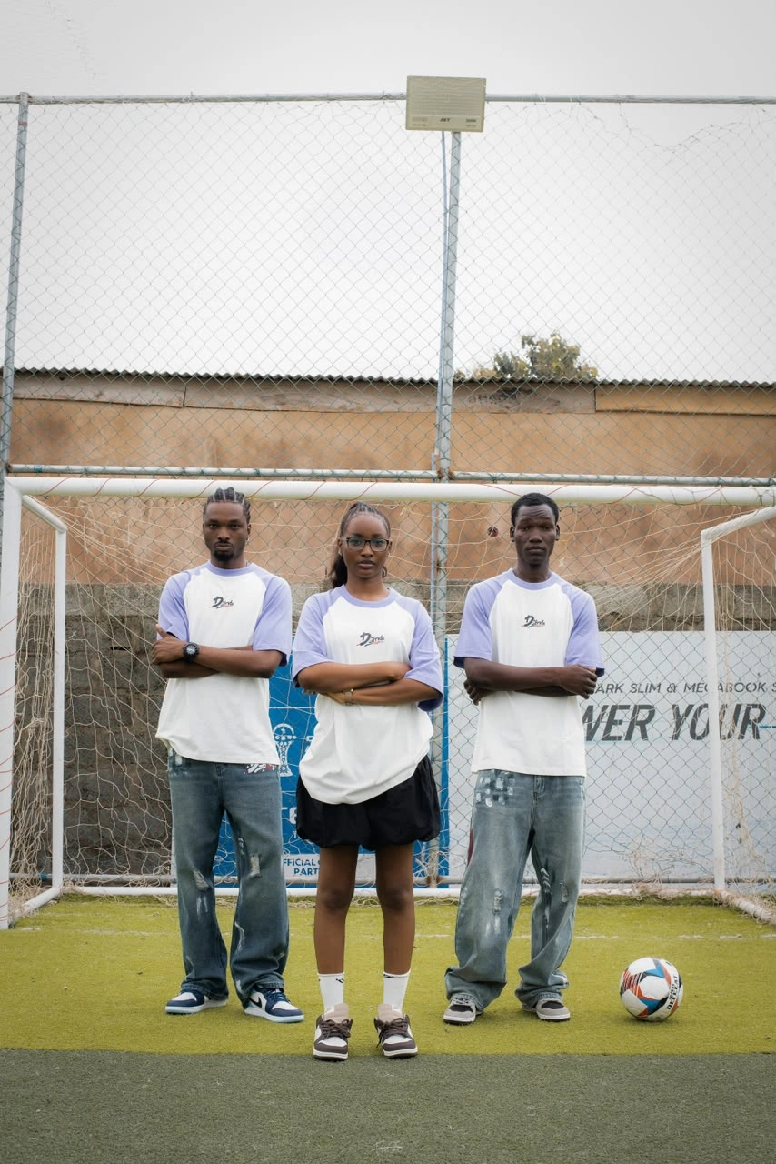 Three models with d'stride outfits on a soccer scenery